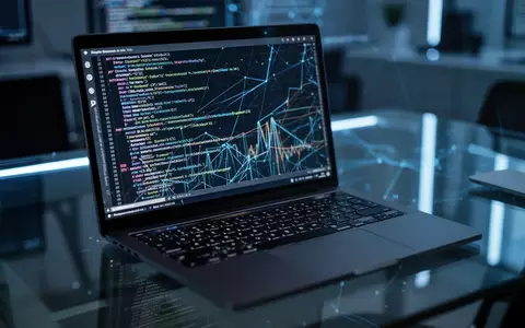 Ein Laptop-Bildschirm zeigt komplexen Programmcode in einem abgedunkelten Büro, was die Analyse einer Spionage-Software symbolisiert. - Foto: über boerse-global.de