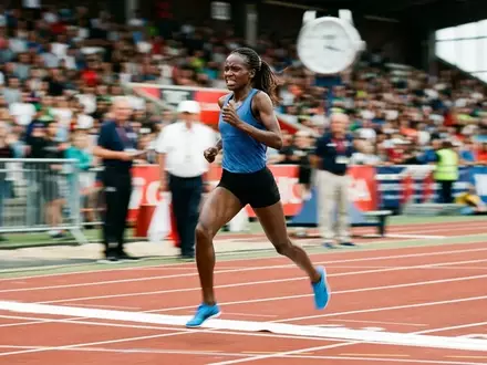 Ein Langstreckenläufer überquert bei einem Leichtathletik-Wettkampf die Ziellinie auf einer Stadionbahn. - Foto: über boerse-global.de
