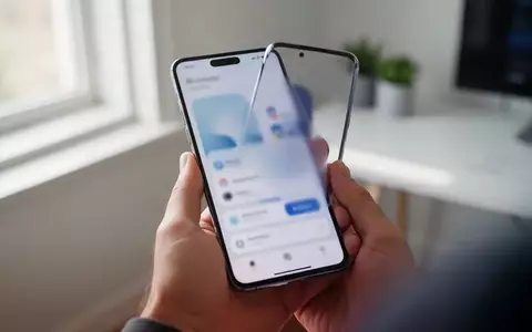 Person hält ein modernes Smartphone in einem hellen Büro, wobei das Display nur unscharf erkennbar ist. - Foto: über boerse-global.de