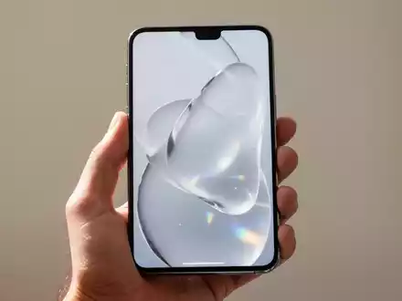 Ein modernes Smartphone mit minimalistischem, transluzentem Glas-Design auf dem Display in einer Hand gehalten. - Foto: über boerse-global.de