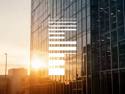 Moderne Glasfassade eines Bürogebäudes im goldenen Licht als Symbol für unternehmerisches Wachstum. - Foto: über boerse-global.de