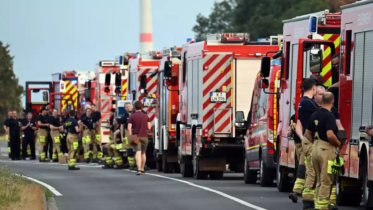 Zahlreiche Kräfte der Feuerwehr stehen an einer Straße. - Bild: Federico Gambarini/dpa