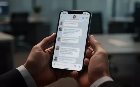 Ein modernes Smartphone in der Hand einer Person, das eine Chat-Oberfläche in einer professionellen Büroumgebung zeigt. - Foto: über boerse-global.de
