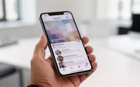 Eine Person hält ein Smartphone in einer hellen Büroumgebung, während sie durch einen sozialen Feed scrollt. - Foto: über boerse-global.de