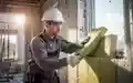 Ein Handwerker bei der professionellen Installation von Dämmmaterialien auf einer Baustelle für nachhaltiges Bauen. - Foto: über boerse-global.de