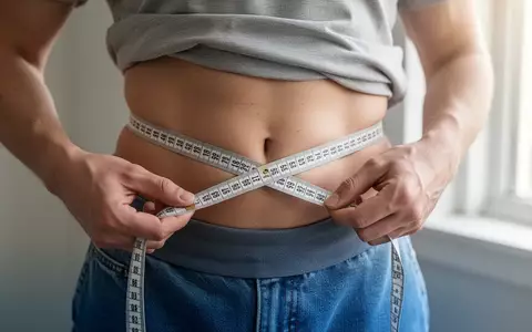 Eine Person misst mit einem Maßband ihren Taillenumfang, um die Fettverteilung am Bauch zu kontrollieren. - Foto: über boerse-global.de