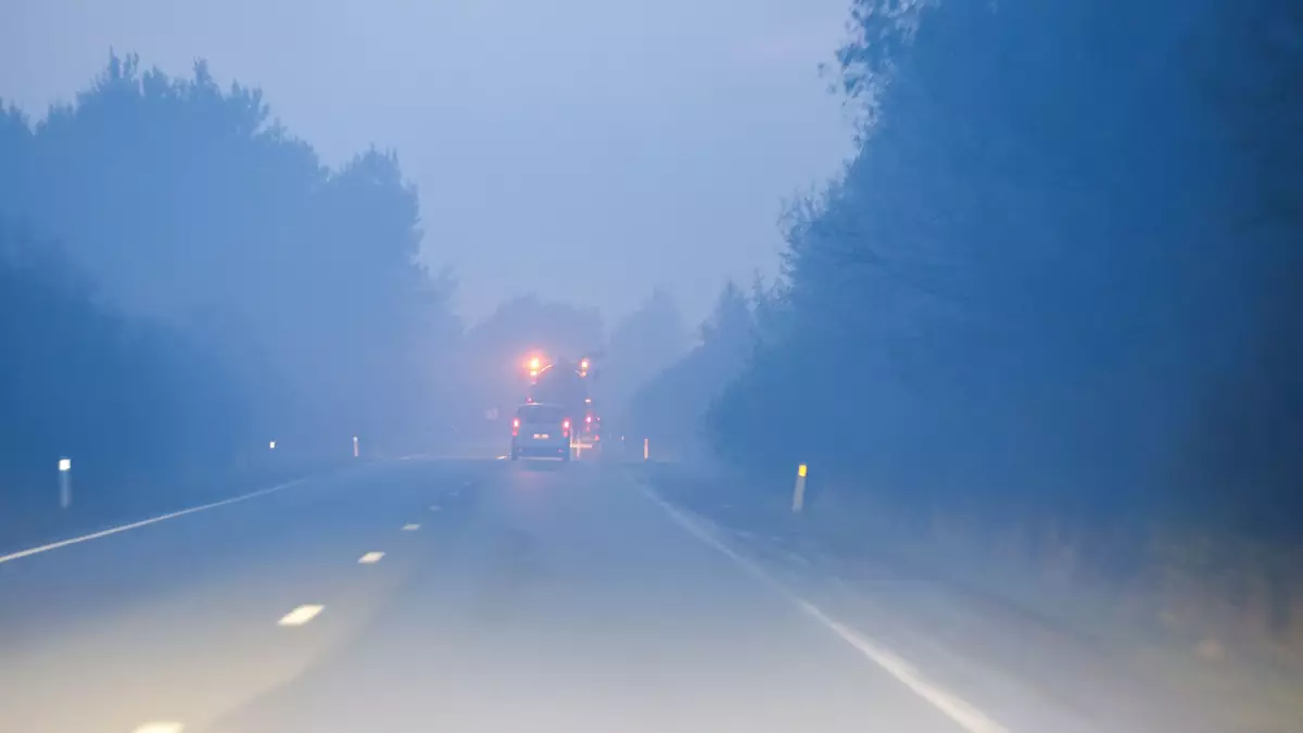 Ein durch den Qualm des Feuers verrauchte Straße bei der Stadt Sourbrodt. - Bild: Thomas Banneyer/dpa