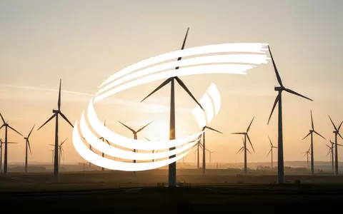 Moderne Windkraftanlagen in einer weiten Landschaft bei Sonnenaufgang als Symbol für erneuerbare Energien. - Foto: über boerse-global.de
