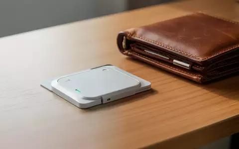 Ein flacher, scheckkartengroßer GPS-Tracker liegt neben einer Lederbrieftasche auf einem Holztisch. - Foto: über boerse-global.de