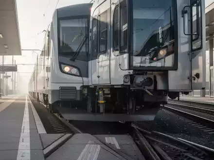 Ein moderner Regionalzug bei der Einfahrt in einen leeren Bahnhof bei Tageslicht. - Foto: über boerse-global.de