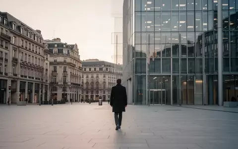 Ein einsamer Geschäftsmann geht in der Morgendämmerung über einen leeren Platz vor einem modernen Bürogebäude. - Foto: über boerse-global.de