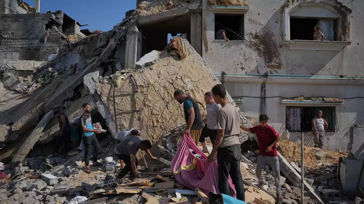 Palästinenser am Ort eines israelischen Luftangriffs im Gazastreifen. (Archivbild) - Bild: Abdel Kareem Hana/AP/dpa