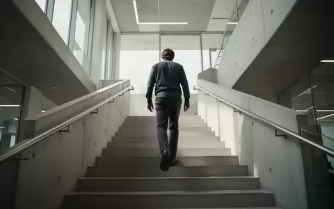 Eine Person steigt eine moderne, helle Betontreppe in einem Gebäude hinauf. - Foto: über boerse-global.de