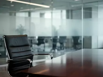 Ein minimalistisches, modernes Büro-Interieur mit einem leeren Bürostuhl und einer Glaswand, das eine Atmosphäre des organisatorischen Umbruchs vermittelt. - Foto: über boerse-global.de