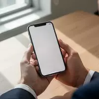 Eine Person hält ein Smartphone in einer hellen Büroumgebung, während sie auf den leeren Bildschirm schaut. - Foto: über boerse-global.de