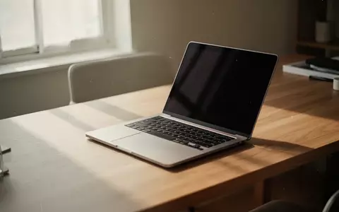 Ein moderner, minimalistischer Arbeitsplatz mit einem aufgeklappten Laptop auf einem Holztisch bei natürlichem Licht. - Foto: über boerse-global.de