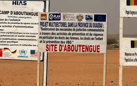 Auf dem Gelände eines Lagers für Flüchtlinge aus dem Sudan im Osten des Tschads stehen die Logos von Hilfsorganisationen, die dort im Einsatz sind. (Archivbild) - Foto: Eva Krafczyk/dpa