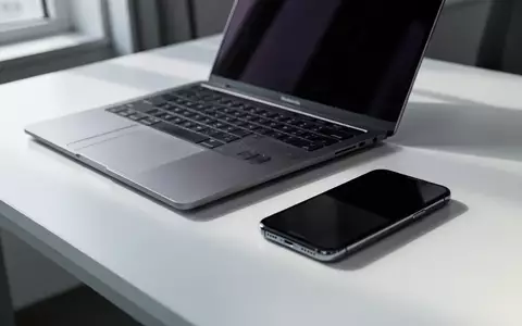 Ein modernes Apple MacBook und ein Smartphone auf einem aufgeräumten Schreibtisch bei natürlichem Tageslicht. - Foto: über boerse-global.de