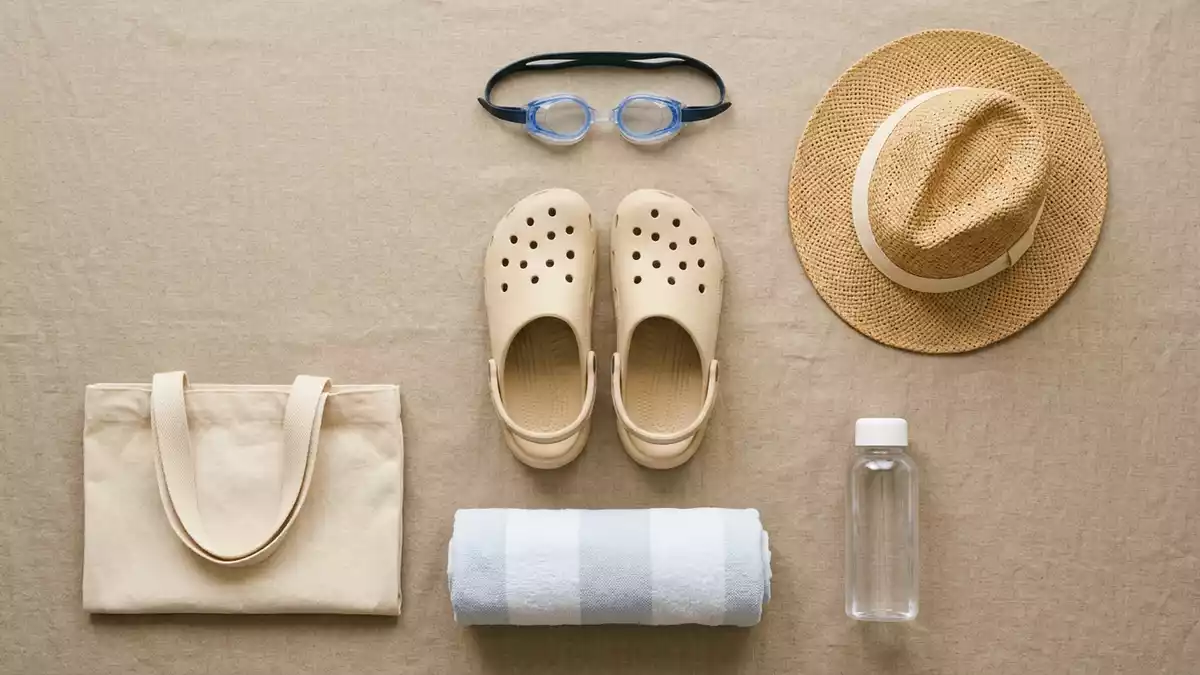 Flatlay-Arrangement rund um Badeclogs mit passenden Requisiten von oben, neutral