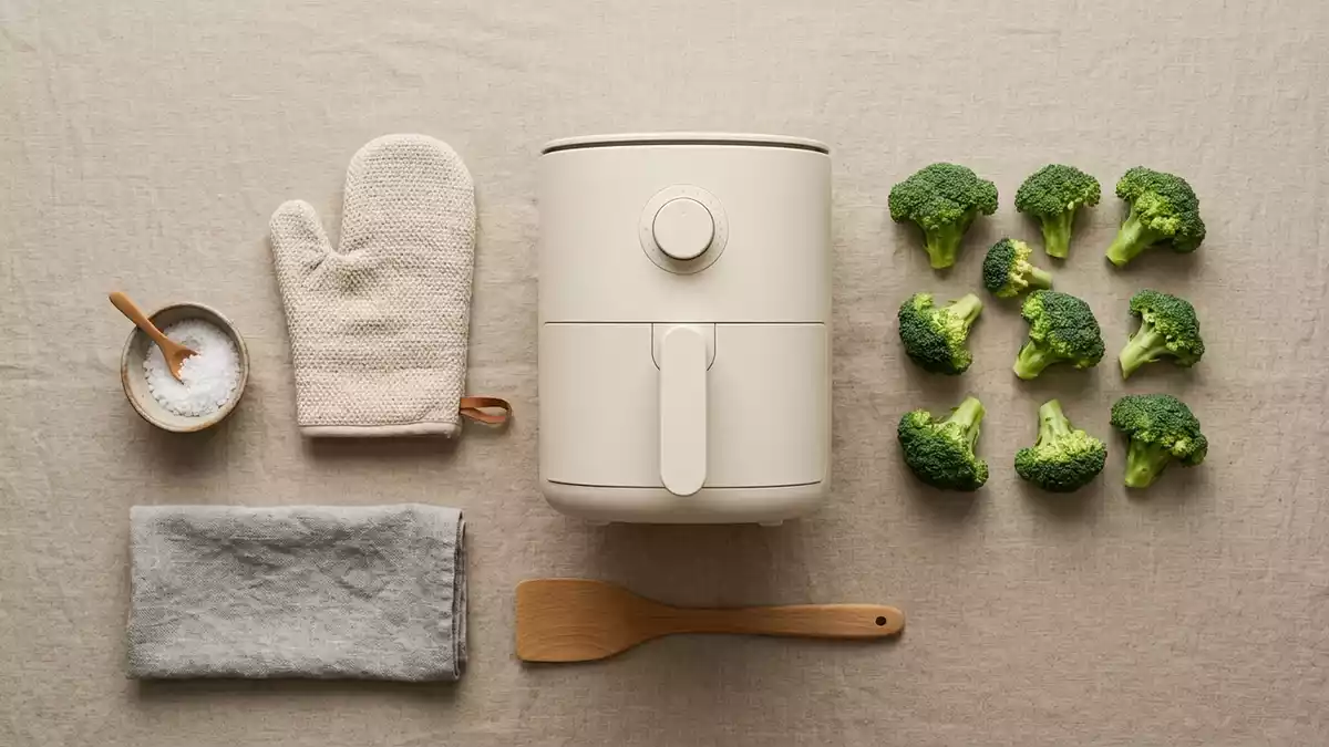 Flatlay-Arrangement rund um Heissluftfritteuse mit passenden Requisiten von oben