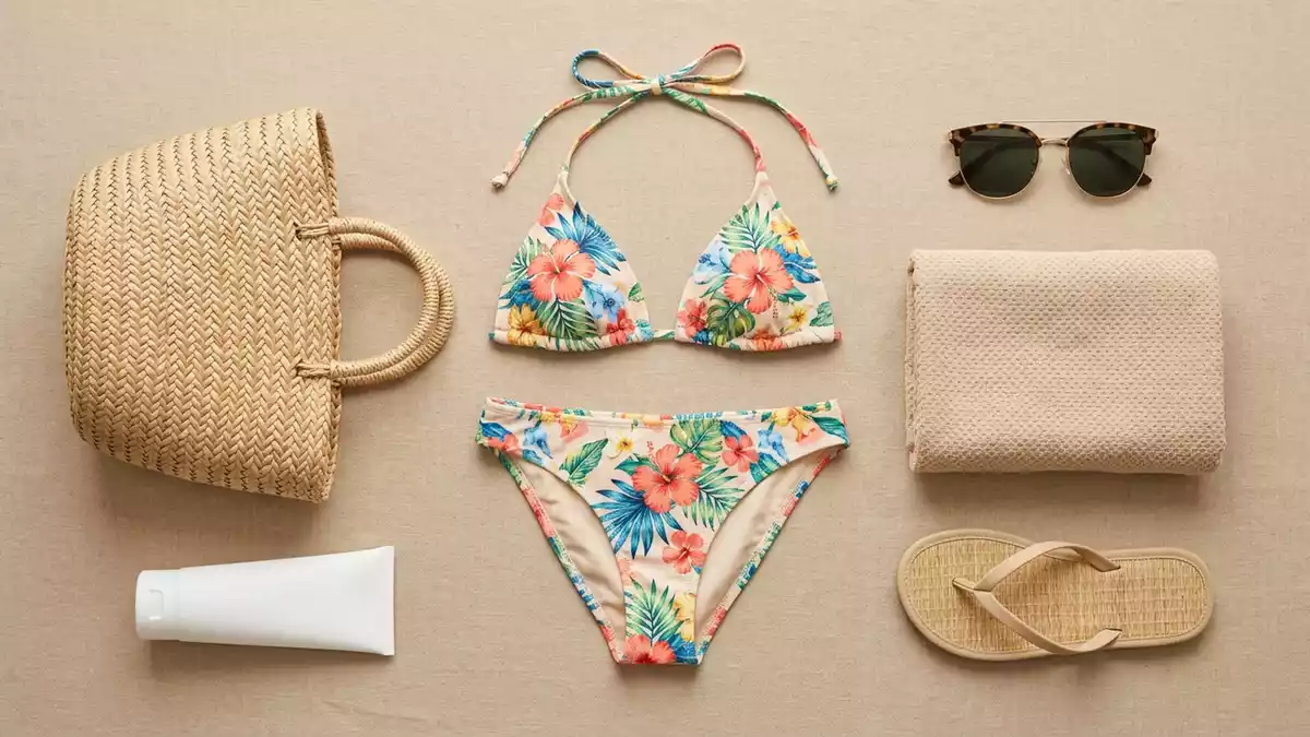 Flatlay-Arrangement rund um Bikini mit passenden Requisiten von oben, neutral