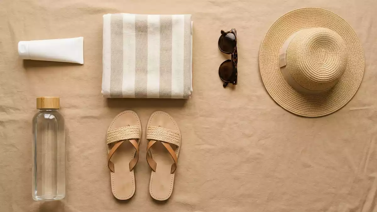 Flatlay-Arrangement rund um Sonnencreme mit passenden Requisiten von oben, neutral