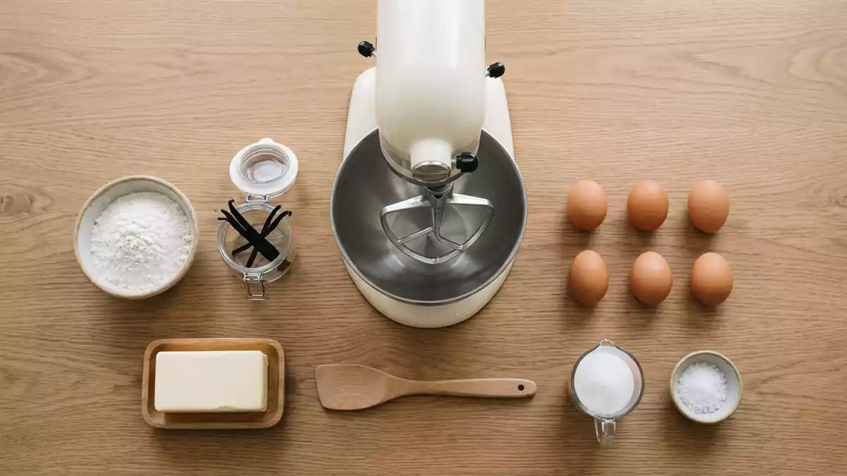 Flatlay-Arrangement rund um Kuechenmaschine mit passenden Requisiten von oben, neutral