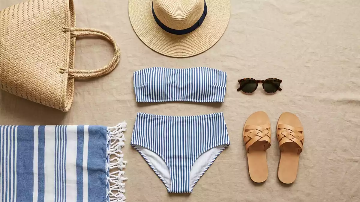 Flatlay-Arrangement rund um Bikini mit passenden Requisiten von oben, neutral