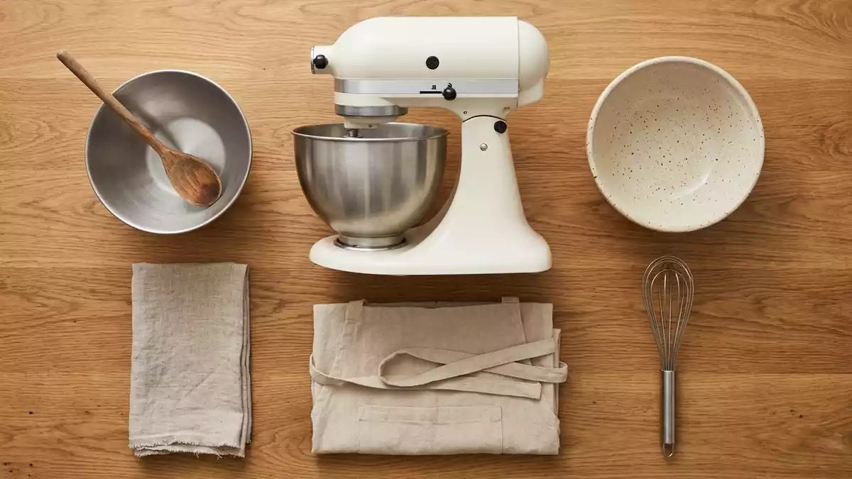 Flatlay-Arrangement rund um Kuechenmaschine mit passenden Requisiten von oben, neutral