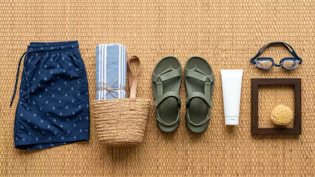 Flatlay-Arrangement rund um Badeshorts mit passenden Requisiten von oben, neutral