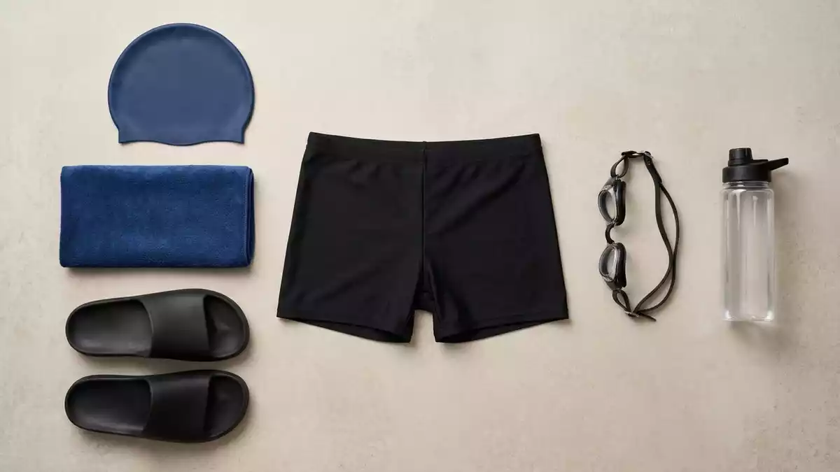 Flatlay-Arrangement rund um Schwimmhose mit passenden Requisiten von oben, neutral