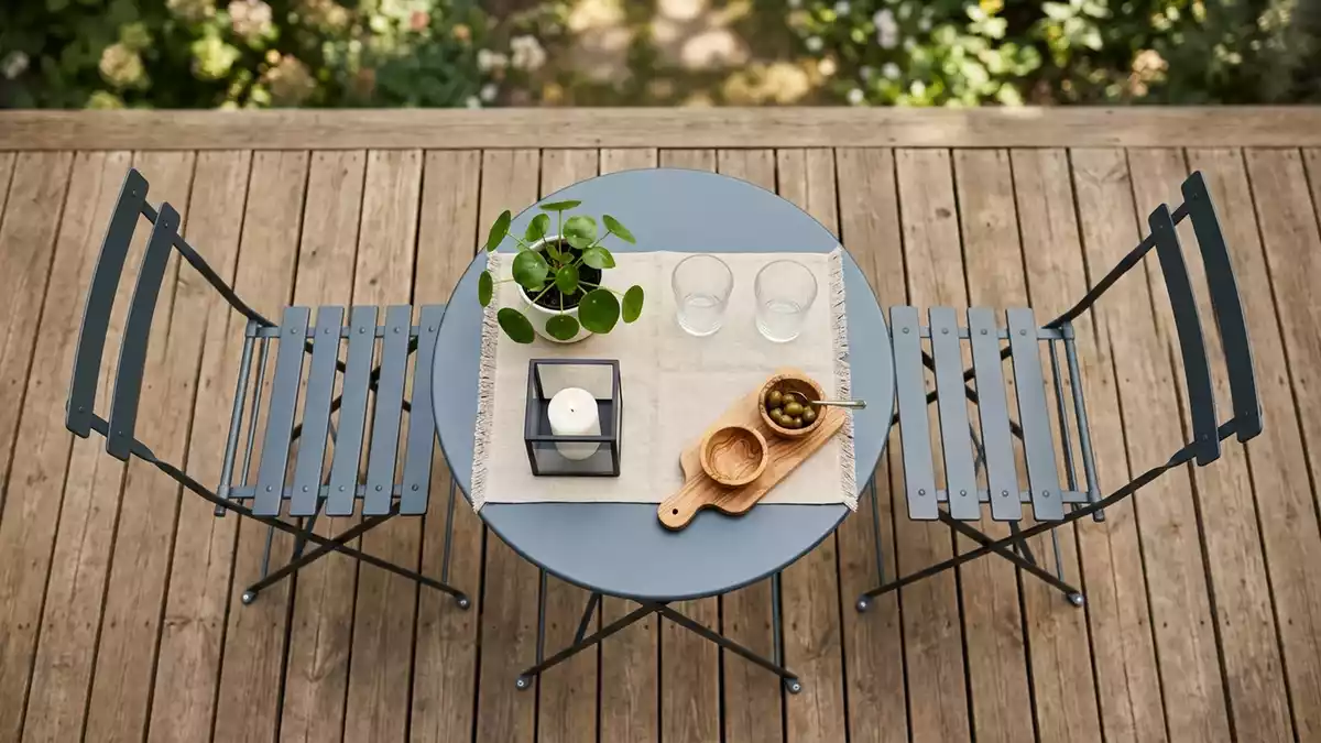 Flatlay-Arrangement rund um Balkonmoebelset mit passenden Requisiten von oben, neutral