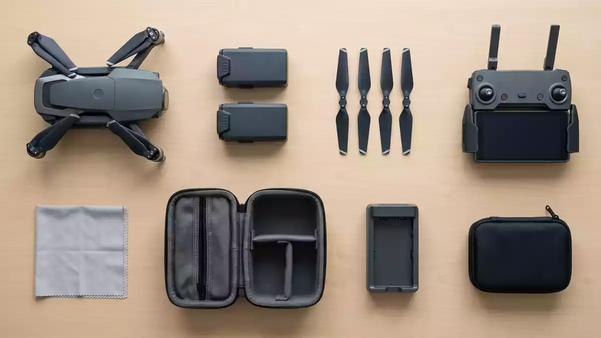 Flatlay-Arrangement rund um Kameradrohne mit passenden Requisiten von oben, neutral