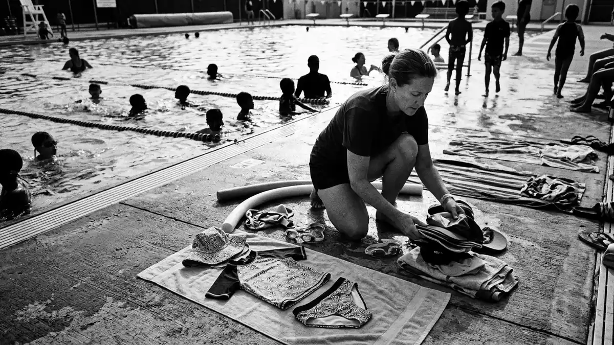 Schwarzweiss-Reportagebild mit Kinder Tankini in dokumentarischer Arbeitsumgebung