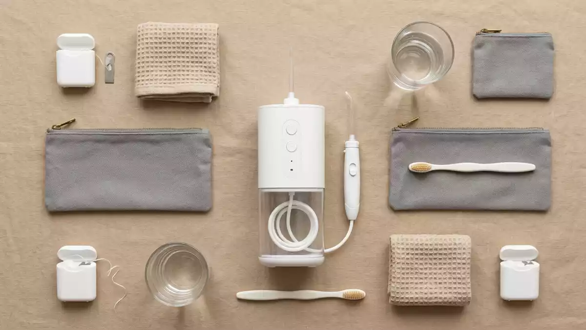 Flatlay-Arrangement rund um Munddusche mit passenden Requisiten von oben, neutral