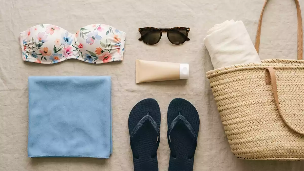 Flatlay-Arrangement rund um Bikinioberteil mit passenden Requisiten von oben, neutral