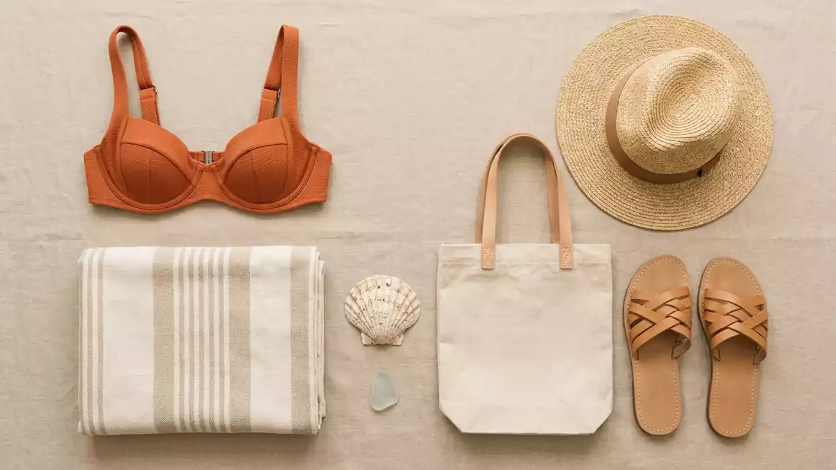 Flatlay-Arrangement rund um Bikinioberteil mit passenden Requisiten von oben, neutral