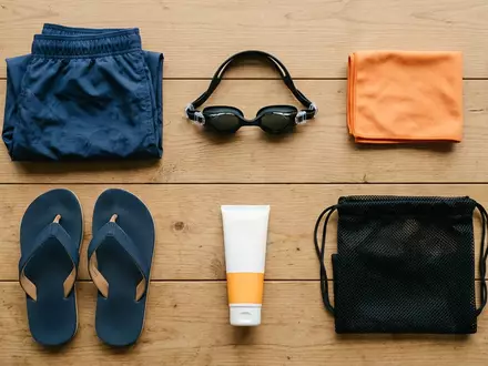 Flatlay-Arrangement rund um Badeshorts zum Thema Versace Herren Badeshorts Medusa, weiches Oberlicht - Foto: THN