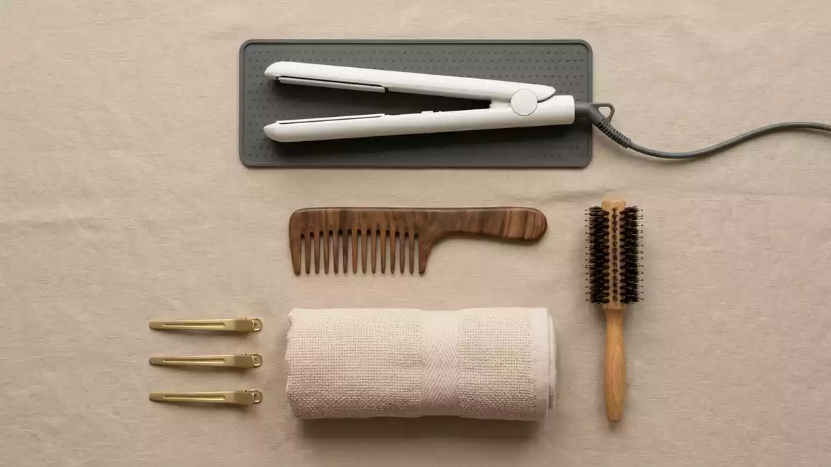 Flatlay-Arrangement rund um Haarglaetter mit passenden Requisiten von oben, neutral