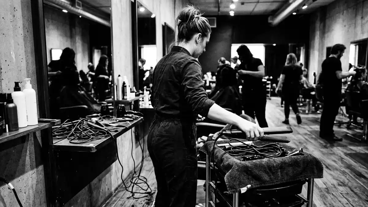 Schwarzweiss-Reportagebild mit Haarglaetter in dokumentarischer Arbeitsumgebung
