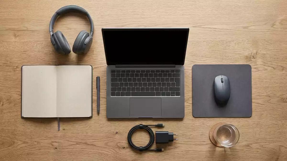 Flatlay-Arrangement rund um Allround-Notebook mit passenden Requisiten von oben