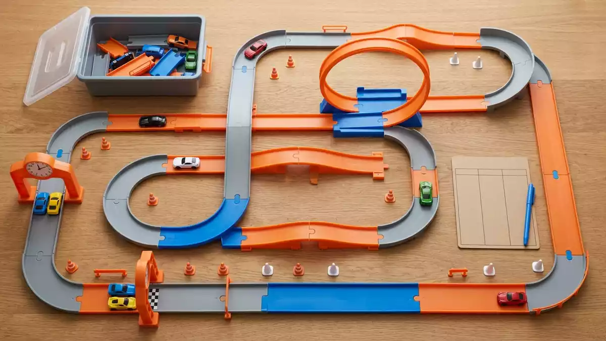 Flatlay-Arrangement rund um Spielzeugstrecke mit passenden Requisiten von oben