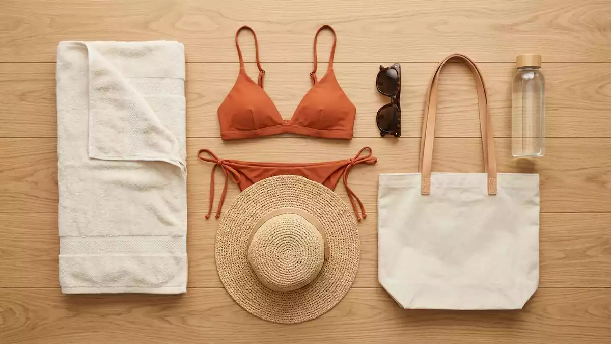 Flatlay-Arrangement rund um Bikini-Set mit passenden Requisiten von oben, neutral
