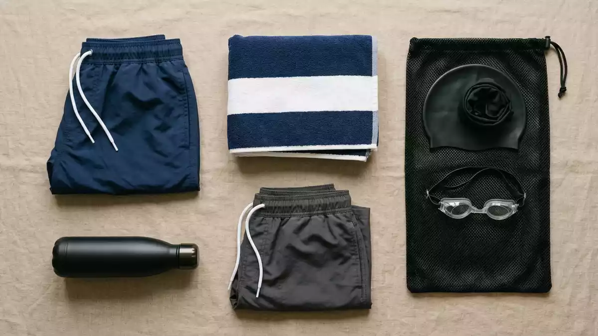 Flatlay-Arrangement rund um Badeshorts mit passenden Requisiten von oben, neutral