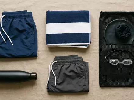 Flatlay-Arrangement rund um Badeshorts zum Thema Adidas Herren 3-Streifen CLX, weiches Oberlicht - Foto: THN