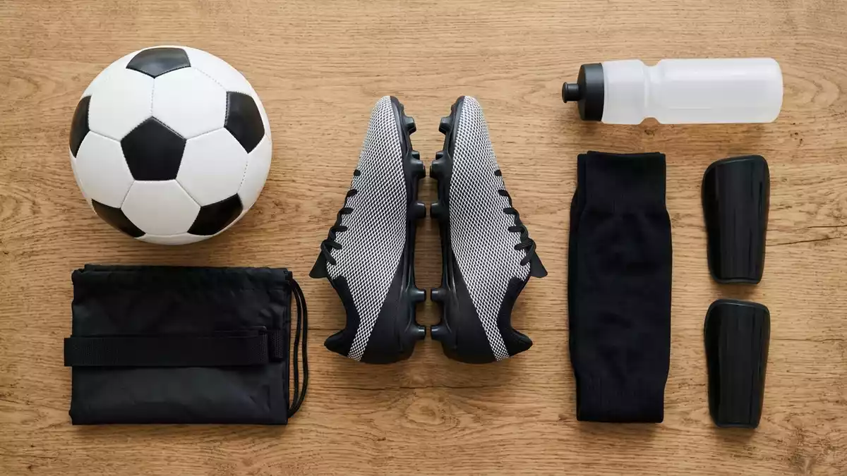 Flatlay-Arrangement rund um Fussballschuhe mit passenden Requisiten von oben, neutral
