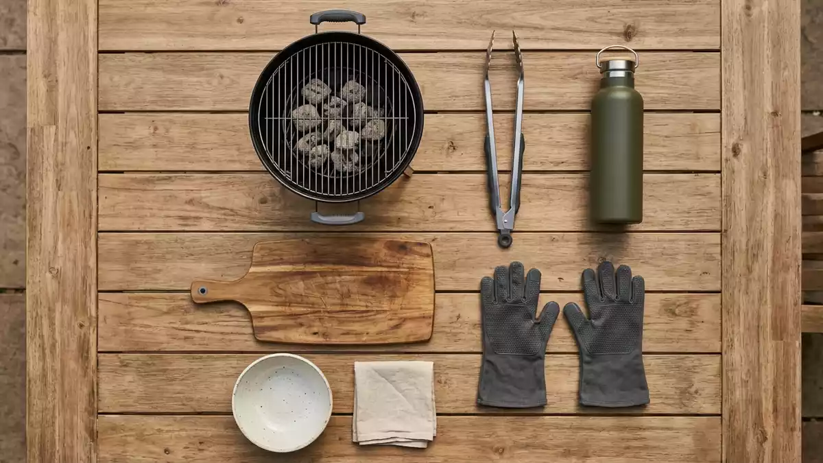 Flatlay-Arrangement rund um Holzkohlegrill mit passenden Requisiten von oben, neutral