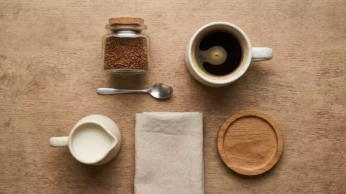 Flatlay-Arrangement rund um Instantkaffee mit passenden Requisiten von oben, neutral