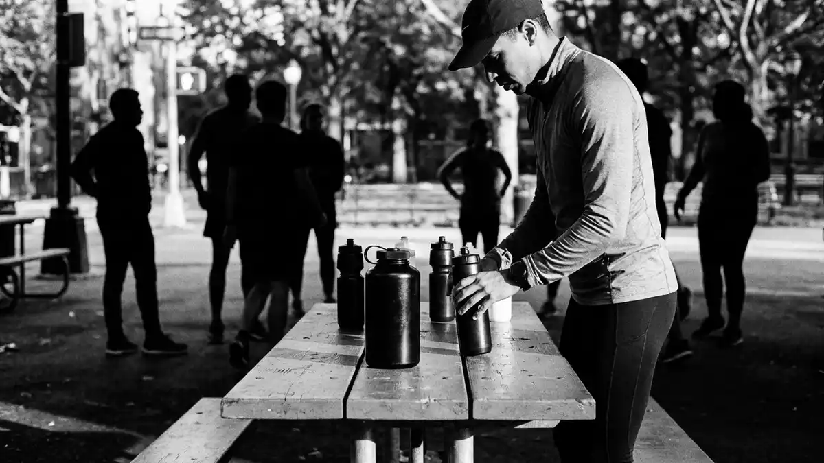 Schwarzweiss-Reportagebild mit Sporttrinkflasche in dokumentarischer Arbeitsumgebung