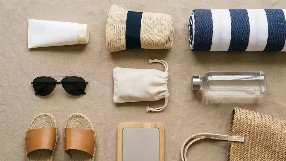 Flatlay-Arrangement rund um Sonnencreme mit passenden Requisiten von oben, neutral